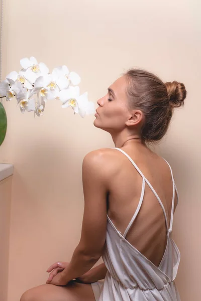 Retrato Una Hermosa Chica Con Una Orquídea Sobre Fondo Claro — Foto de Stock