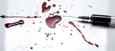 Şırınga ve kan beyaz bir arka plan üzerine sıçradı. Bir sürü kan ve bir şırınga..