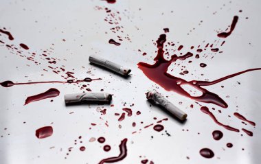 Sigara izmaritleri ve beyaz arka plan da kan. Sigaranın neden olduğu akciğer kanseri kavramı.