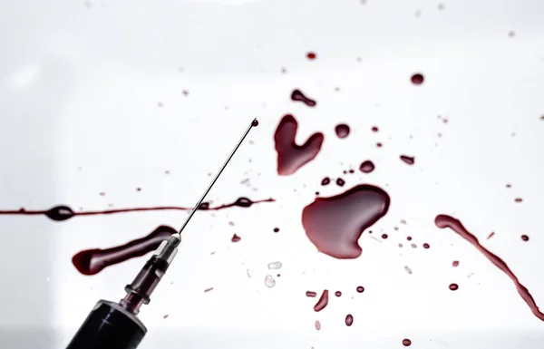 注射器和血溅在白色背景上 大量的血液和注射器 — 图库照片