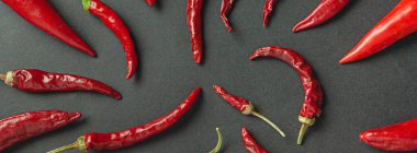 Siyah arka planda bir sürü kırmızı biber ve karabiber var. Yukarıdan görüntüle.