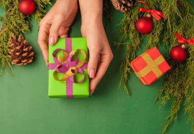 Renkli kâğıt ve kurdelelerden elde yapılan bayram hediyesi, kadın eliyle. Yukarıdan görüntüle.