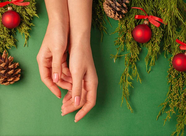 Kerst Achtergrond Met Dennenspeelgoed Vrouwelijke Handen Bovenaanzicht Een Groene Achtergrond — Stockfoto