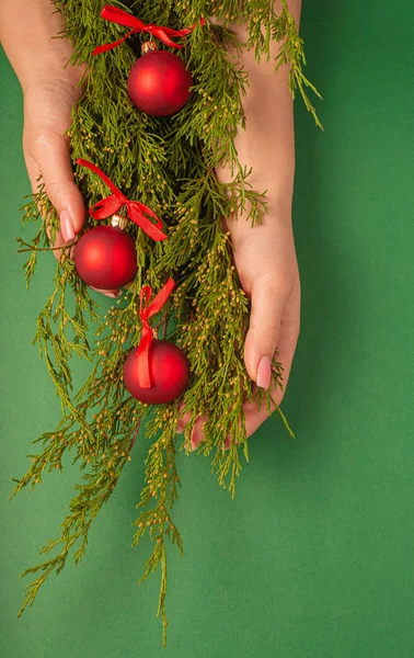 Kerst Achtergrond Met Dennenspeelgoed Vrouwelijke Handen Bovenaanzicht Een Groene Achtergrond — Stockfoto