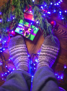Noel ağacının yanındaki örgü çorapların içinde hediyelerle duruyorum..