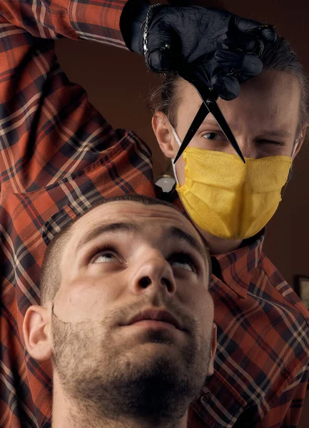 男性理发师 戴着防护面具和手套 穿着休闲装 没有面具的客户检疫后理发 健康预防措施 小企业 Coronavirus大流行病的后果 — 图库照片