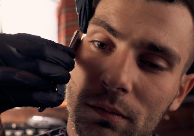 Berber kuaförde bir adamı kesmiş. Kısa saç kesimi ve saç hatları. Bir müşterinin yakın portresi. Saç bakımı.