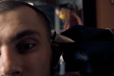 Berber kuaförde bir adamı kesmiş. Kısa saç kesimi ve saç hatları. Bir müşterinin yakın portresi. Saç bakımı.