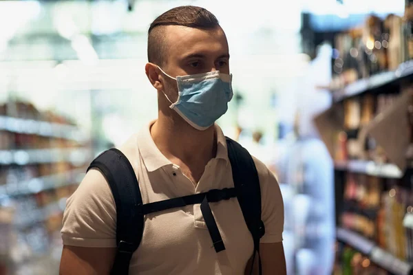 一个戴着医疗面具的家伙在超市里走来走去 公共场所用于健康的个人防护设备 — 图库照片