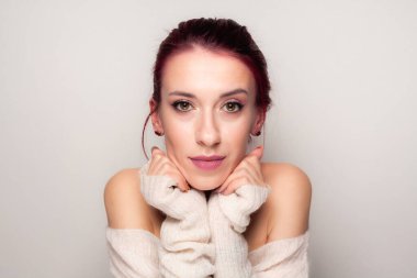 Hafif arka planda makyaj yapan bir kızın portresi..