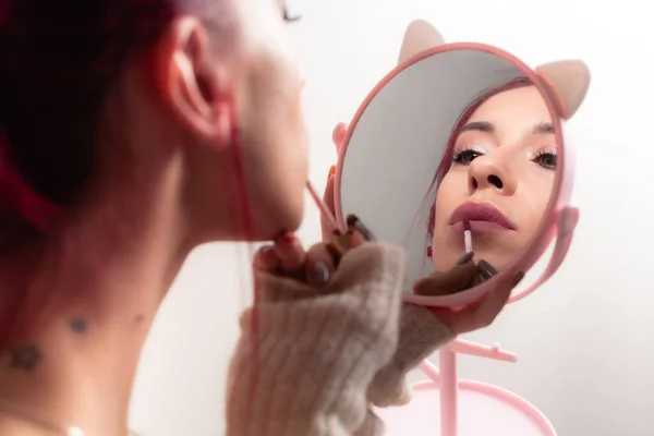 소녀는 립스틱으로 입술을 물들여 거울을 미모와 화장을 립스틱으로 입술을 물들여 — 스톡 사진