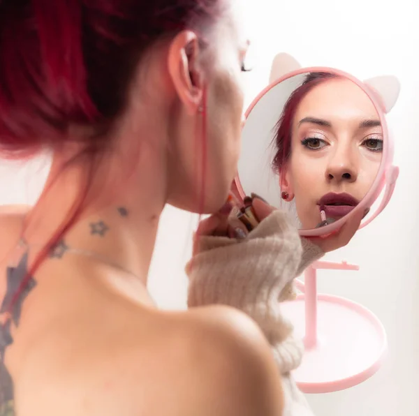 소녀는 립스틱으로 입술을 물들여 거울을 미모와 화장을 립스틱으로 입술을 물들여 — 스톡 사진