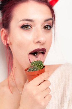 Komik kız kaktüsü yalıyor.