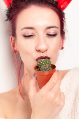 Komik kız kaktüsü yalıyor.