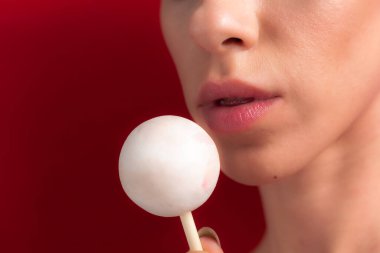 Kadın dudaklarını ve şekerlerini kapat. Çubukta şeker yiyen bir kız. Güzel dudaklar.
