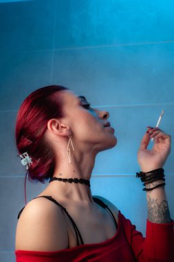 Kız sigara içiyor. Kendine güvenen bayan..