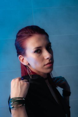 Kızıl saçlı, yakından çekilmiş yüz resmi. Makyajlı kendinden emin bir kız..