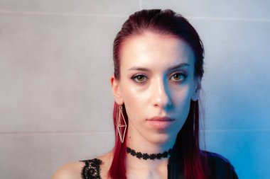 Kızıl saçlı, yakından çekilmiş yüz resmi. Makyajlı kendinden emin bir kız..