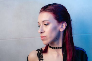 Kızıl saçlı, yakından çekilmiş yüz resmi. Makyajlı kendinden emin bir kız..