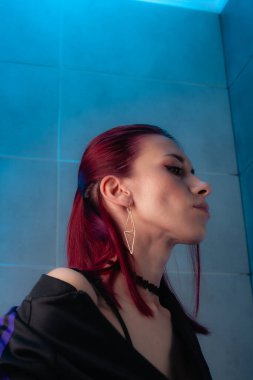 Kızıl saçlı, yakından çekilmiş yüz resmi. Makyajlı kendinden emin bir kız..