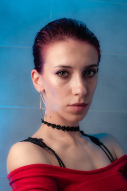 Kızıl saçlı, yakından çekilmiş yüz resmi. Makyajlı kendinden emin bir kız..