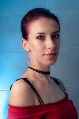 Kızıl saçlı, yakından çekilmiş yüz resmi. Makyajlı kendinden emin bir kız..