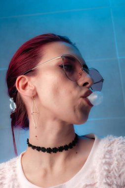 Kızıl saçlı, yakından çekilmiş yüz resmi. Makyajlı kendinden emin bir kız..