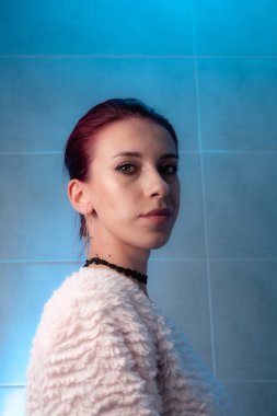 Kızıl saçlı, yakından çekilmiş yüz resmi. Makyajlı kendinden emin bir kız..