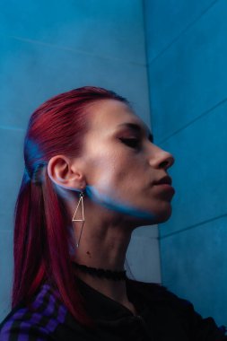 Kızıl saçlı, yakından çekilmiş yüz resmi. Makyajlı kendinden emin bir kız..