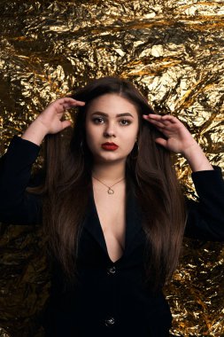 Altın bir arka planda siyah ceketli şık tombul bir kız..