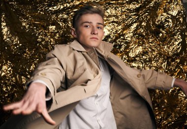 Bej ceketli, altın kaplama beyaz gömlekli şık bir adam..