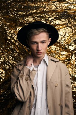 Bej ceketli, altın kaplama beyaz gömlekli şık bir adam..