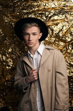 Bej ceketli, altın kaplama beyaz gömlekli şık bir adam..