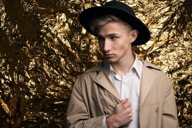 Bej ceketli, altın kaplama beyaz gömlekli şık bir adam..