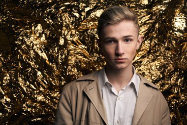 Bej ceketli, altın kaplama beyaz gömlekli şık bir adam..