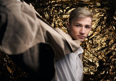 Bej ceketli, altın kaplama beyaz gömlekli şık bir adam..