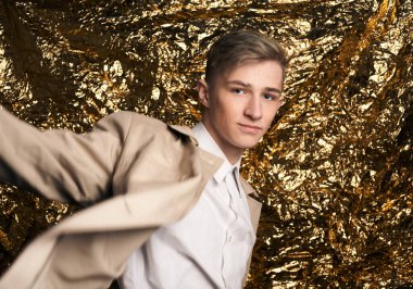 Bej ceketli, altın kaplama beyaz gömlekli şık bir adam..