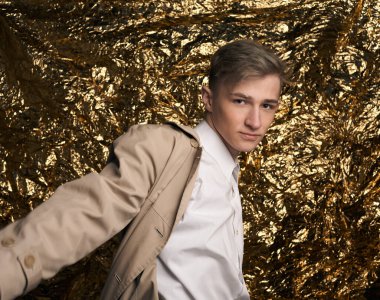 Bej ceketli, altın kaplama beyaz gömlekli şık bir adam..