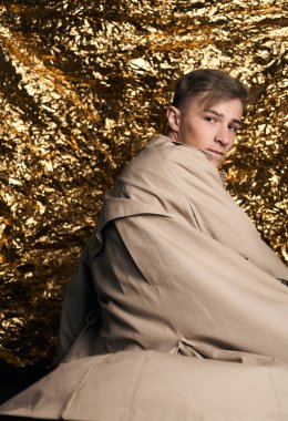 Bej ceketli, altın kaplama beyaz gömlekli şık bir adam..