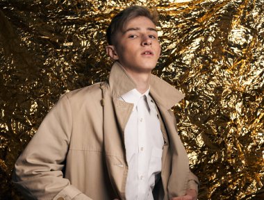 Bej ceketli, altın kaplama beyaz gömlekli şık bir adam..