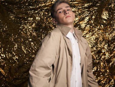 Bej ceketli, altın kaplama beyaz gömlekli şık bir adam..