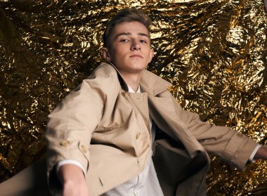 Bej ceketli, altın kaplama beyaz gömlekli şık bir adam..