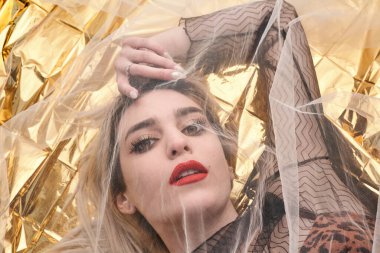 Altın folyoda, tül kumaşın altında güzel bir kız..