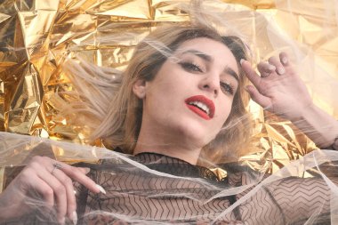 Altın folyoda, tül kumaşın altında güzel bir kız..