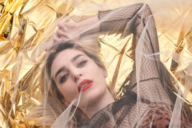 Altın folyoda, tül kumaşın altında güzel bir kız..