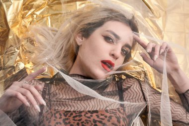 Altın folyoda, tül kumaşın altında güzel bir kız..