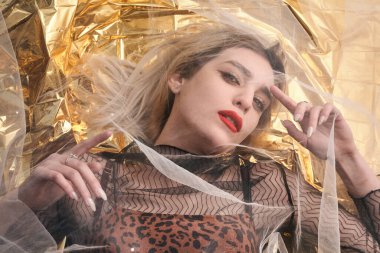 Altın folyoda, tül kumaşın altında güzel bir kız..