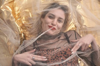 Altın folyoda, tül kumaşın altında güzel bir kız..