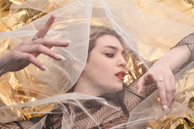 Altın folyoda, tül kumaşın altında güzel bir kız..