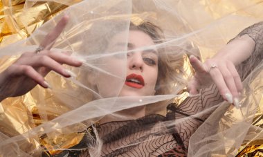 Altın folyoda, tül kumaşın altında güzel bir kız..